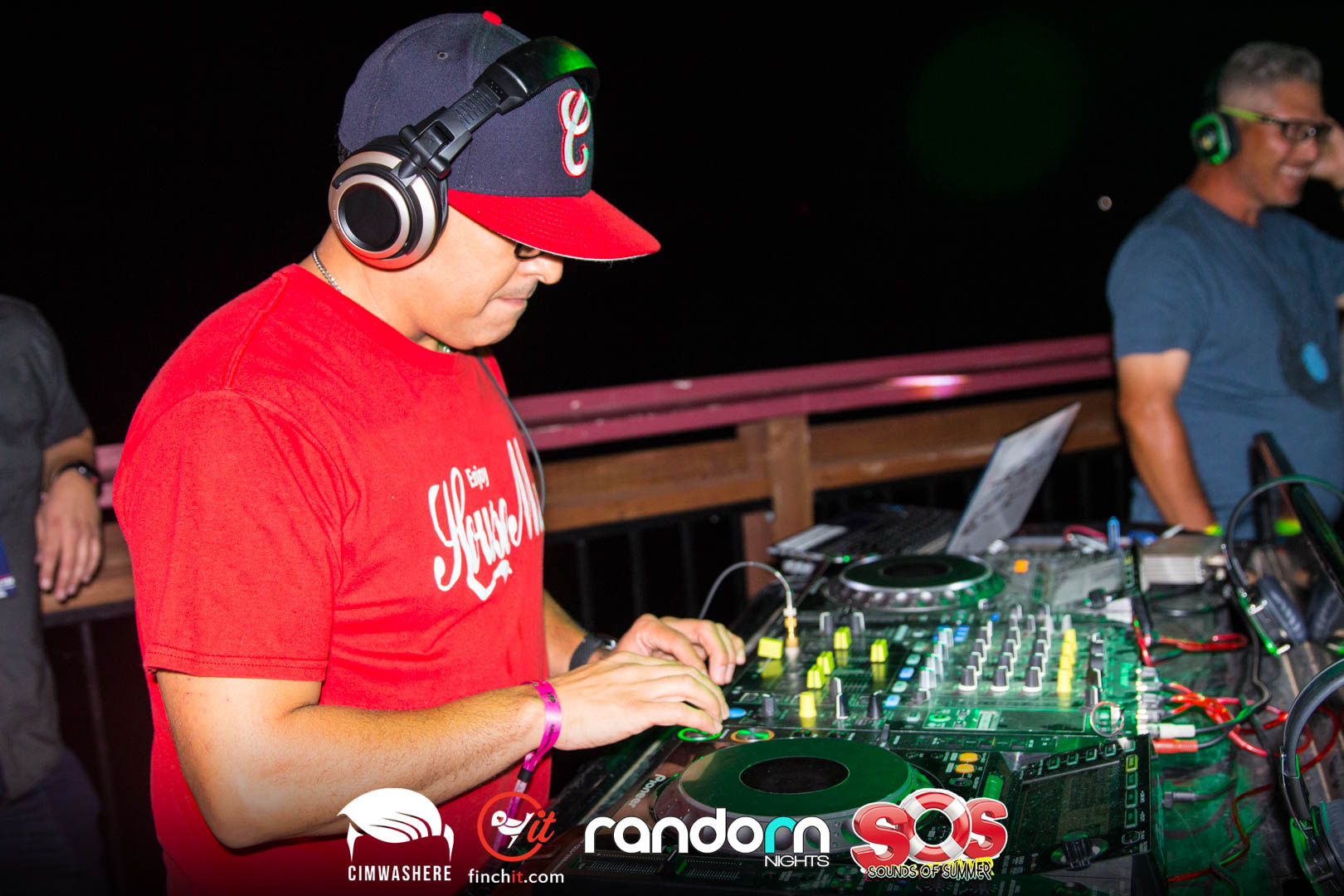 DJ in a red cap under stage light
